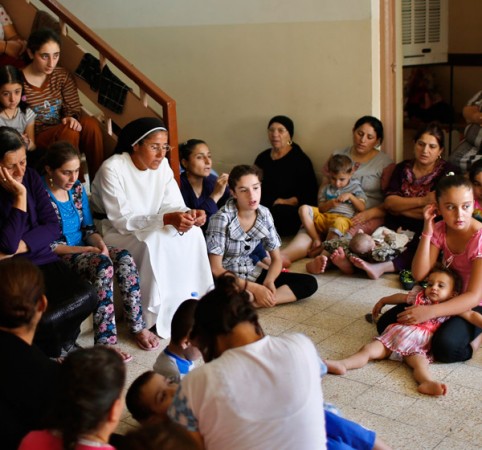 A group of displaced people from Mosul sit inside a school in Irbil.