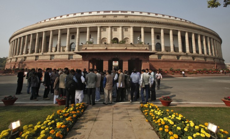 People stand in front of the Indian parliament building on the opening day of the winter session in New Delhi November 22, 2012. Winter Session Parliament