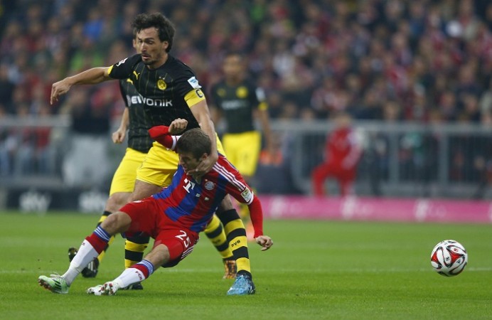 Borussia Dortmund defender Mats Hummels tackles Bayern Munich forward Thomas Muller during their Bundesliga game Mats Hummels Borussia Dortmund Thomas Muller Bayern Munich