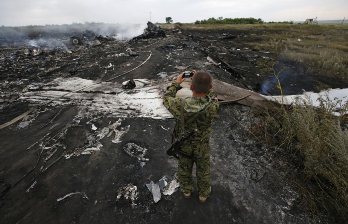 An armed pro-Russian separatist takes pictures at the site of a Malaysia Airlines Boeing 777 plane crash, MH17, near the settlement of Grabovo in the Donetsk region on 17 July 2014. It has been announced that the wreckage of Malaysia Airlines flight MH17 will be photographed, scanned and categorized as part of the crash probe. Malaysian Airlines Flight MH17 wreckage to be photographed