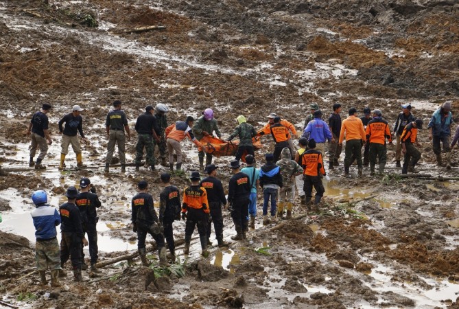 Indonesian soldiers and rescue team members move a dead body after a landslide hit the village of Sampang in Banjarnegara, December 13, 2014 Indonesia landslide