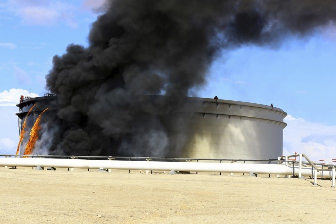 Black smoke billows out of a storage oil tank in the port of Es Sider in Ras Lanuf December 25, 2014. A rocket hit a storage tank at the eastern Libyan oil of port Es Sider as armed factions allied to competing governments fought for control of the country's biggest export terminal, officials said on Thursday. Libya Clashes