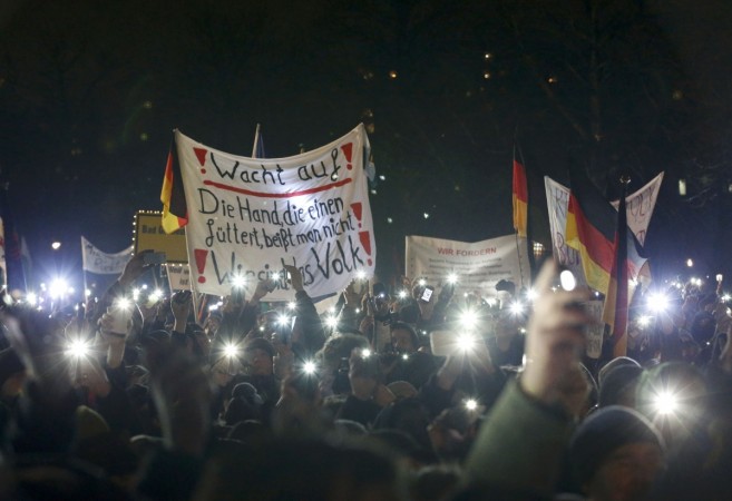 Participants use lights on their portable phones as they take part in a demonstration called by anti-immigration group PEGIDA, a German abbreviation for Participants use lights on their portable phones as they take part in a demonstration called by anti-immigration group PEGIDA, a German abbreviation for