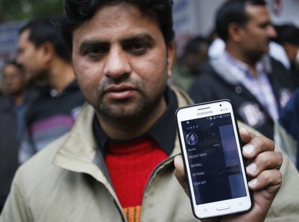 An Uber taxi driver shows an application software in his mobile phone used to track the taxi's location, during a protest against the ban on online taxi services, in New Delhi A taxi driver in Delhi