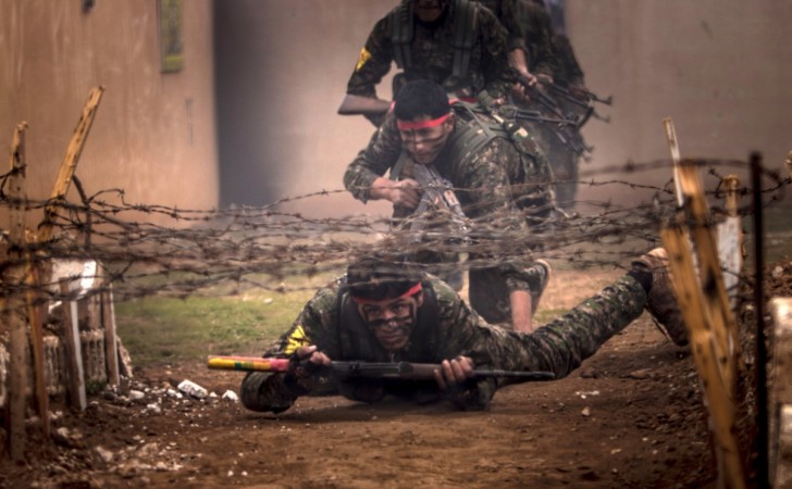 Fighters of the Kurdish People's Protection Units (YPG) crawl under barbed wires with their weapons at a military training camp in Ras al-Ain February 13, 2015. Fighters of the Kurdish People's Protection Units (YPG) crawl under barbed wires with their weapons at a military training camp in Ras al-Ain February 13, 2015.