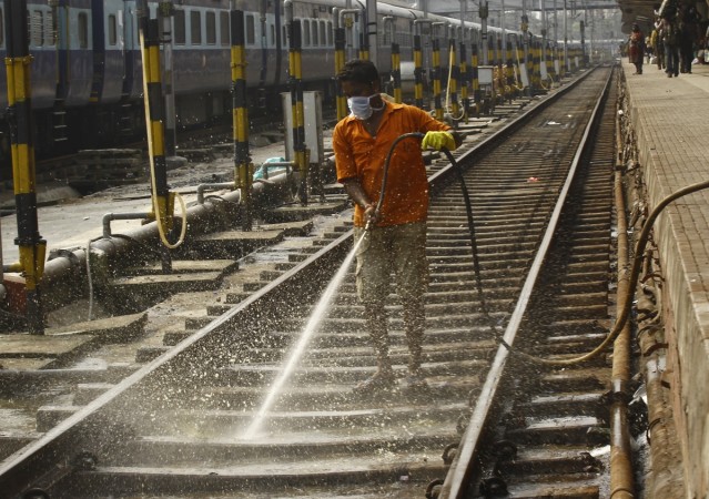 A worker cleans a railway track at a railway station in Kolkata Indian Railways