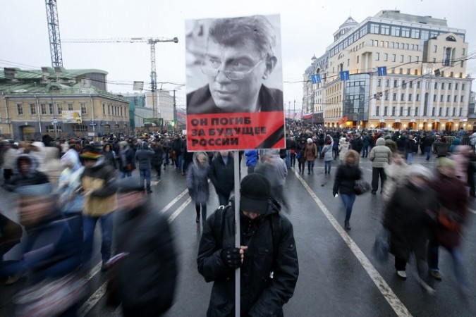 A man holds a poster of Kremlin critic Boris Nemtsov, who was shot dead on Friday night, during a march to commemorate him in central Moscow March 1, 2015. A man holds a poster of Kremlin critic Boris Nemtsov, who was shot dead on Friday night, during a march to commemorate him in central Moscow March 1, 2015.