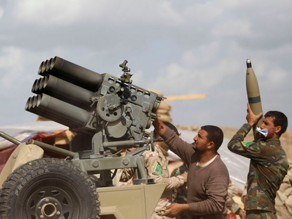 Iraqi security forces and Shia fighters reload a weapon during clashes with Islamic State militants in Salahuddin province March 2, 2015.