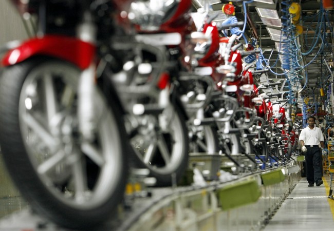 A worker walks beside newly built motorbikes at the Bajaj Auto Ltd. plant in Pune, about 130 km (82 miles) from Mumbai August 9, 2007. Bajaj motorcycle ltd.