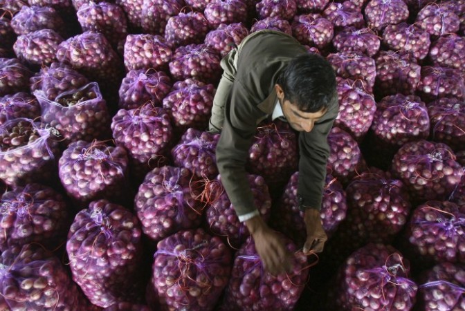 A worker packs onion bags at a wholesale vegetable market in Chandigarh onion