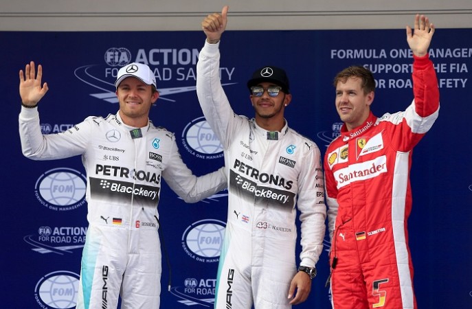Mercedes driver Lewis Hamilton of Britain (C) waves after taking pole position next to team mate Nico Rosberg (L) of Germany and Ferrari Formula One driver Sebastian Vettel of Germany following the qualifying session of the Chinese Grand Prix at the Shanghai International Chinese Grand Prix