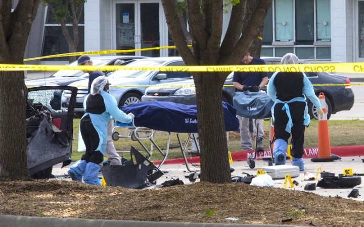 Personnel remove the bodies of two gunmen who opened fire on a security officer on Sunday outside a venue in Dallas, Texas.