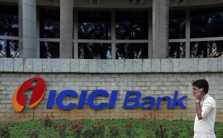 A pedestrian walks past a logo of ICICI Bank at its headquarters in Mumbai January 30, 2015. ICICI Bank