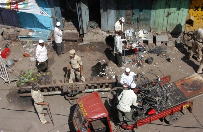Local residents and policemen clear debris at a blast site in Malegaon, about 260km from Mumbai, September 30, 2008. 2008 Malegaon Blasts