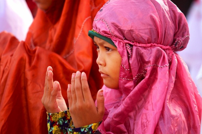 A girl prays during the morning prayers of Eid al-Fitr outside the Pink Mosque in Datu Saudi Ampatuan town, Maguindanao province in southern Philippines. Eid al-Fitr 2015