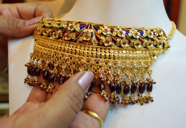 A woman touches a gold necklace at a jewellery store during Karva Chauth festival in the northern Indian city of Allahabad October 17, 2008 (representational image). gold prices in india, gold stocks, titan share price, tbz share price, gold consumption, gold jewellery in india, wgc gold demand