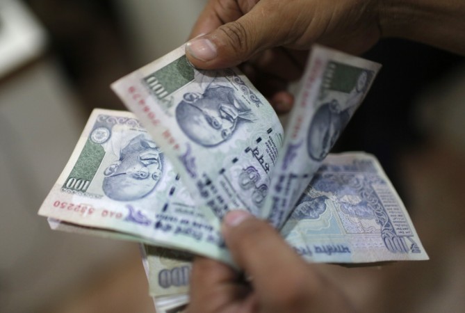 An employee counts Indian rupee currency notes inside a private money exchange office in New Delhi July 5, 2013
