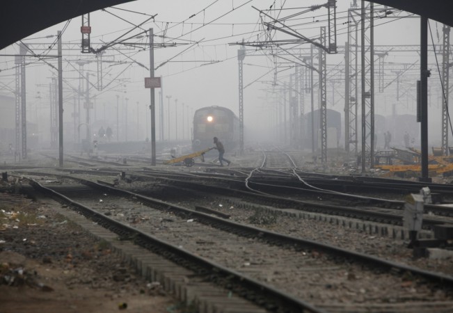 rail stocks wagons engineering texmaco kalindee titagarh rail nirman indian railways prabhu track renewal expansion infra push govt A labourer pushes a handcart past a train as he crosses railway tracks on a foggy and cold winter morning in New Delhi Janu
