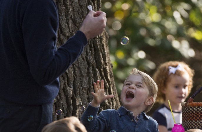 Prince George reacts to bubbles being blown by his father the Duke of Cambridge. Prince George