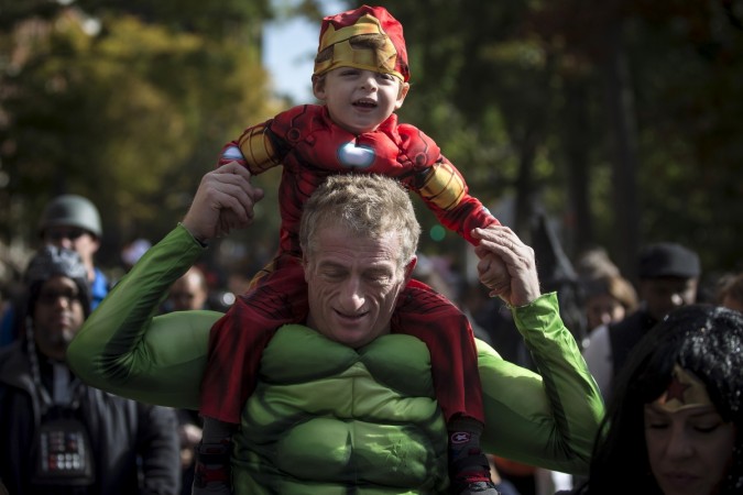 Pictured: Child dressed as Ironman rides on an adult's shoulders who is dressed up as the Hulk on Halloween. Halloween
