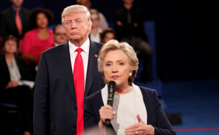 Republican U.S. presidential nominee Donald Trump listens as Democratic nominee Hillary Clinton answers a question from the audience during their presidential town hall debate at Washington University in St. Louis, Missouri, U.S., October 9, 2016. Donald Trump, Hillary Clinton