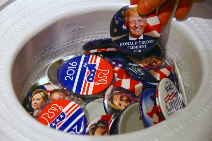 A guest at an event called the U.S. Presidential Election Watch, organised by the U.S. Consulate, reaches for a badge from out of a hat displaying photographs of Republican candidate Donald Trump and Democratic candidate Hillary Clinton, in Sydney, Australia, November 9, 2016. US presidential elections