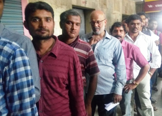 People queue up outside a public-sector bank in Bengaluru to exchange their currency notes. Queue