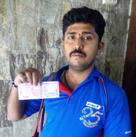 Venkatesh shows the Rs 2,000 currency note he just obtained from a bank in Bengaluru on Thursday, November 10, 2016. Rs 2000 note