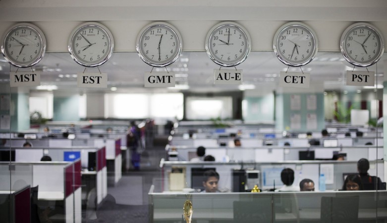 Workers are pictured beneath clocks displaying time zones in various parts of the world at an outsourcing centre in Bangalore February 29, 2012 (representational image). indian it companies, it hiring, it jobs, recruitment in it companies, infosys hiring, infosys vishal sikka, tcs hiring, h1b visa, h1 b visa, donald trump, hcl tech