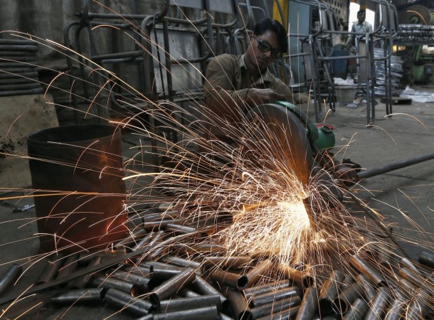 A worker cuts a metal pipe inside a steel furniture production factory in the western Indian city of Ahmedabad February 2, 2015. India steel production