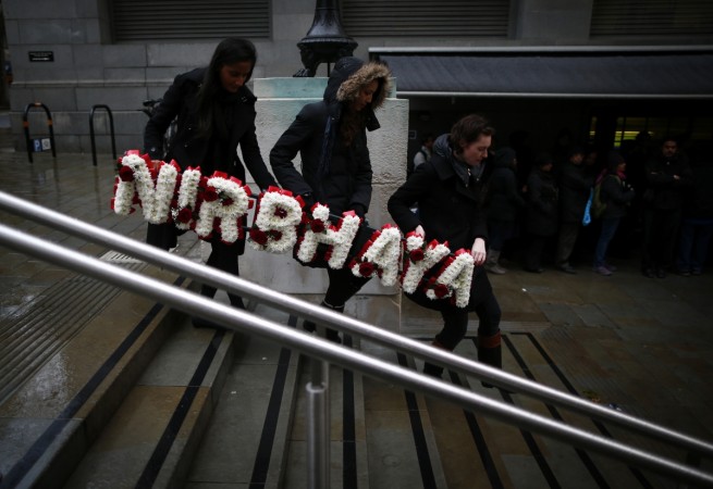 In picture: Women carry a floral tribute at an event to mark the anniversary of the brutal gang rape of a student on a bus in Delhi, outside the Indian High Commission in central London, December 16, 2013. Nirbhaya