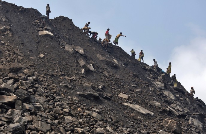 Locals collect coal from the dumpsite of an open coal field of Coal India Limited (CIL) at Dhanbad district in the eastern Indian state of Jharkhand. CIL plans to recruit about 9,000 people including 4,000 at the executive level to fill up the backlog of retired hands. (A representational image) ntpc coal jharkhand mines india cil coal india share price net profit reserves billion exploration power energy