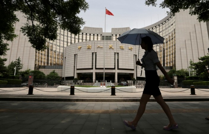 A woman walks past the headquarters of the People's Bank of China (PBOC), the central bank, in Beijing, June 21, 2013. china, pboc, pboc to relax lending norms, chinese banks, chinese economy