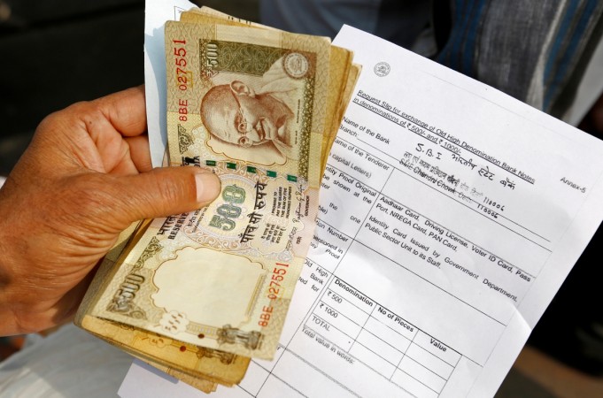 A person stands with his documents in a queue outside a branch of the State Bank of india as people wait to exchange old high denomination bank notes in Old Delhi, India, November 10, 2016. demonetisation, rbi, remonetisation, notes returned, bank deposits, modi