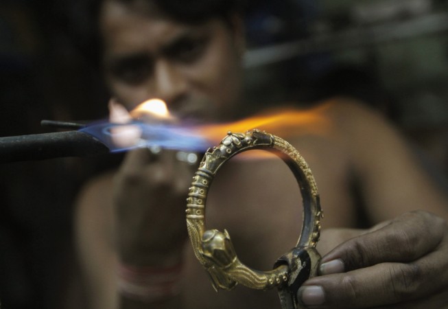 A goldsmith works on a gold bangle at a workshop in Kolkata January 16, 2013. gold prices, gold demand, gold outlook, silver prices, silver demand, india news, wgc gold demand