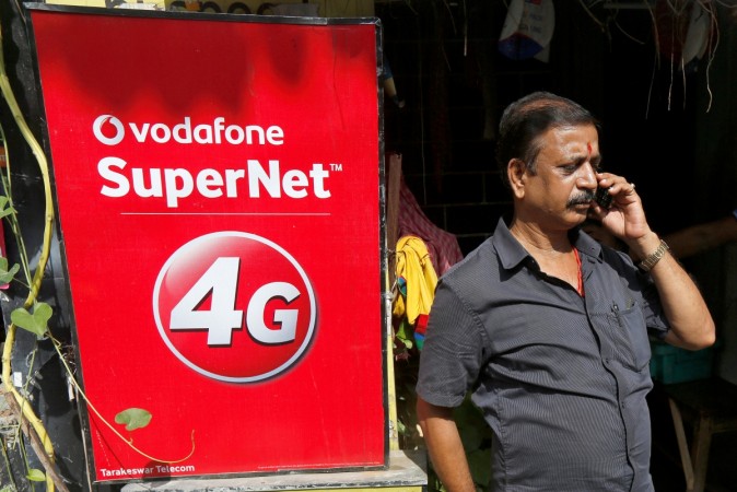 A man speaks on his mobile phone next to a Vodafone advertisement in Kolkata, India, September 26, 2016. A man speaks on his mobile phone next to a Vodafone advertisement in Kolkata