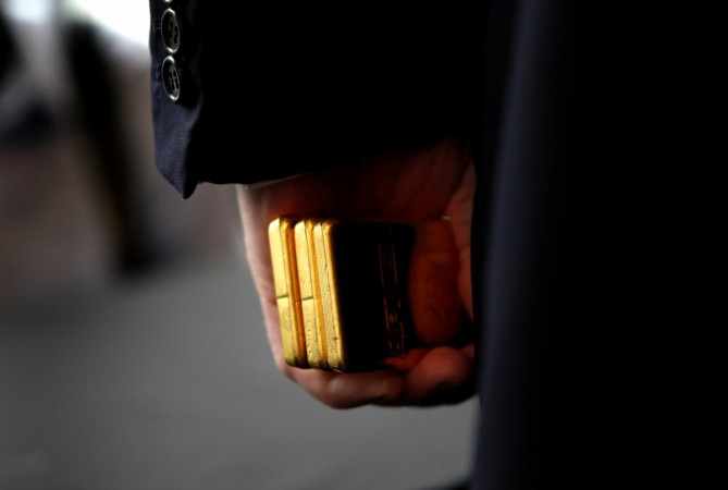 Donald Trump holds three bars of gold bullion in New York, U.S., September 15, 2011. weird news, gold bars, gold prices, golds jewellery, gold weapons, gold car, gold dragon, gold reserves, gold lingerie
