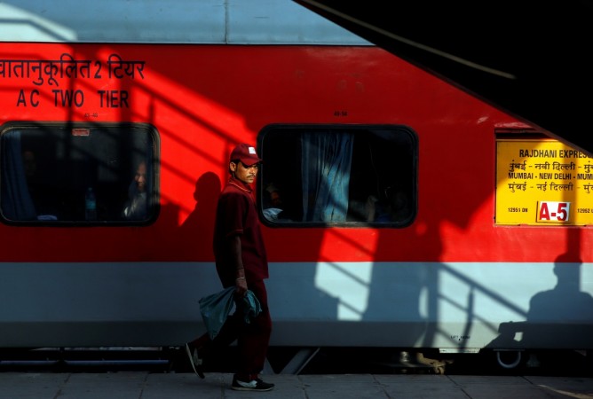 A member of staff walks beside a train in the New Delhi railway station, India February 1, 2017. union budget 2017, rail budget 2017, railway budget 2017, listing of rail psus, ircon, irfc, irctc, online railway tickets, profile of irctc