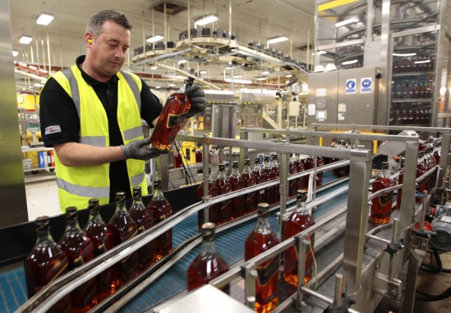 A worker looks at a bottle of Johnnie Walker whisky at the Diageo owned Shieldhall bottling plant in Glasgow, Scotland March 24, 2011. diageo, united spirits, usl share price, diageo to hike sale in usl, vijay mallya owned usl, ub group