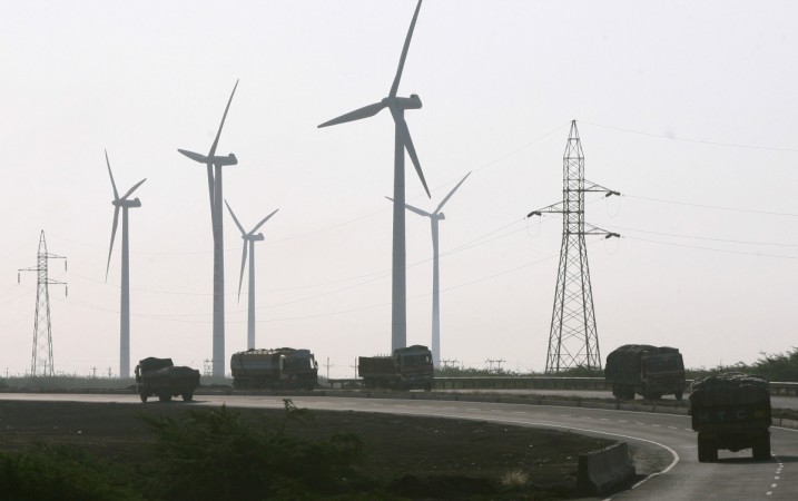 Trucks travel along a national highway in front of power generating wind turbines at Suzlon wind farm at Surajbari village, about 275 km (171 miles) west of the western Indian city of Ahmedabad, December 14, 2009 (representational image). india wind power tariff, india wind energy, india solar energy, solar parks in india, re projects, piyush goyal, modi govt, india news