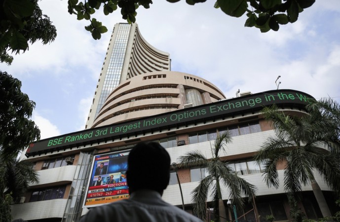 A man looks at a screen across the road on the facade of the Bombay Stock Exchange (BSE) building in Mumbai May 16, 2014. sensex at all time high, sensex at new high, indian stock markets, djia at record high, djia makes history