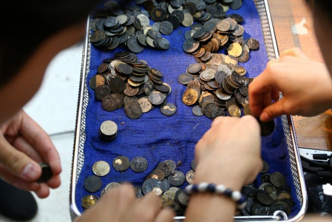 Officers count coins that were removed from the stomach of Omsin, a 25 year old female green sea turtle, after a surgical operation at the Faculty of Veterinary Science, Chulalongkorn University in Bangkok, Thailand March 6, 2017. green sea turtle, Omsin, coins, operation, Bangkok,