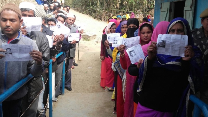 Voters show their voter ID cards as they wait in a queue to cast their vote at a polling booth during the second phase of Manipur Legislative Assembly polls in Manipur on March 8, 2017. Manipur exit polls, manipur election results 2017, manipur assembly election