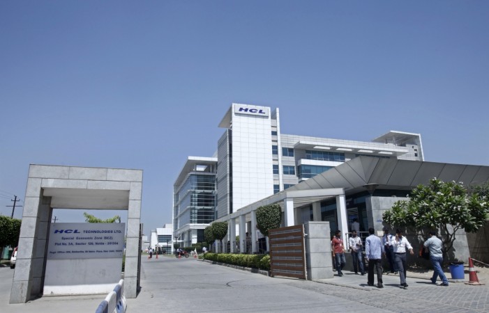 People walk in front of the HCL Technologies Ltd office at Noida, on the outskirts of New Delhi April 17, 2013. hcl tech share price, hcl tech share buyback, infosys buyback, indian it companies, sensex gainers, sensex losers