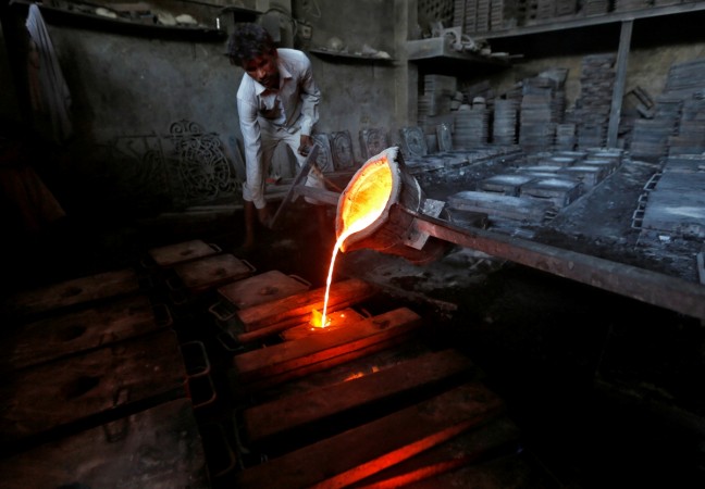 A worker pours molten iron from a ladle to make lamp posts inside an iron casting factory in Ahmedabad, India March 1, 2017. india, india news, india pmi march 2017, india, rbi repo rate, india inflation