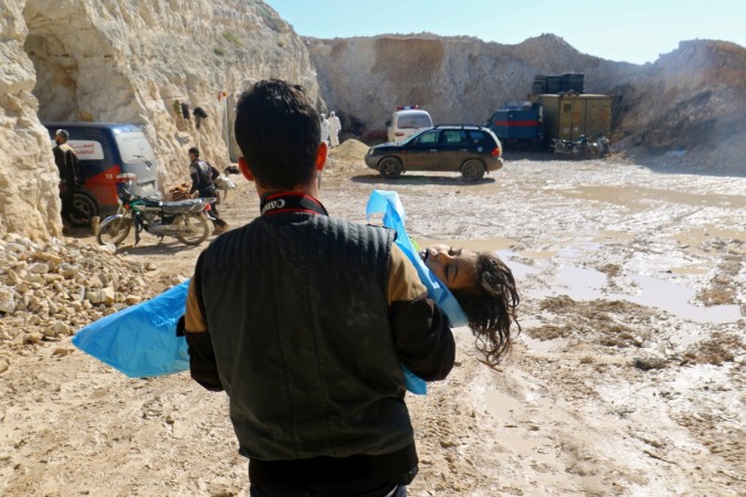A man carries the body of a dead child, after what rescue workers described as a suspected chemical attack in Syria. Syria chemical attack