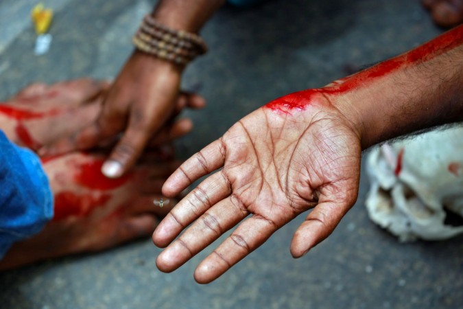 A farmer from the southern state of Tamil Nadu rubs blood on a fellow protestors feet after deliberately cutting himself with a razor blade during a protest demanding a drought-relief package from the federal government, in New Delhi, India April 7, 2017. Tamil Nadu Farmers