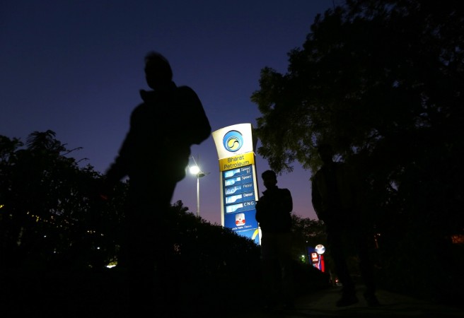 A Bharat Petroleum oil pump station displays the price of unleaded petrol (0.89$) and diesel (0.66$) as pedestrians walk past in New Delhi, India, February 3, 2016 ppac march 2017 report, india crude oil import, india oil and gas sector at a glance, bpcl, hpcl, ioc, ongc, fuel stations in india