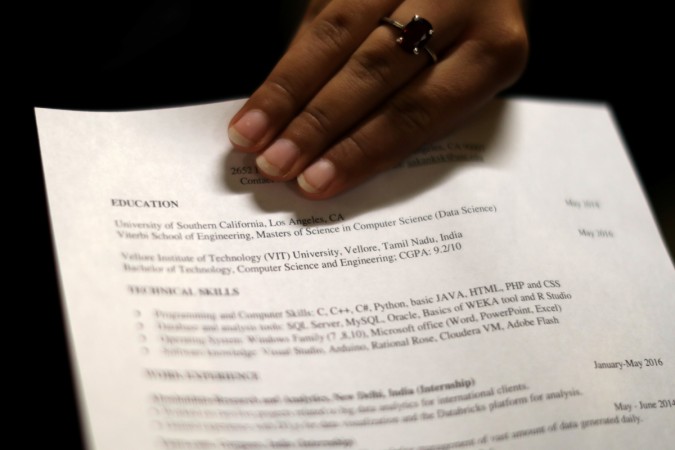 A woman holds her resume at TechFair LA, a technology job fair, in Los Angeles Résumé