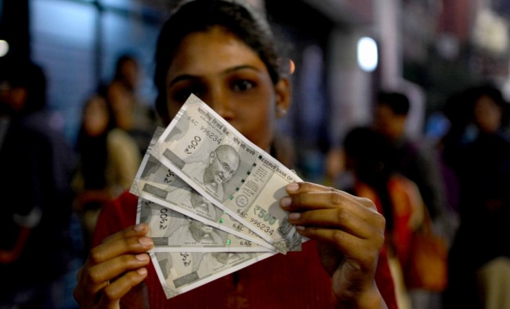 A woman shows the new Rs 500 denomination currency note outside an ATM kiosk in Kolkata on Nov. 20, 2016 (representational image). salaries of mf executives, hdfc mf salaries, hdfc mf ceo milind barve salary, reliance mf sundeep sikka salary, icici mf nimesh shah salary